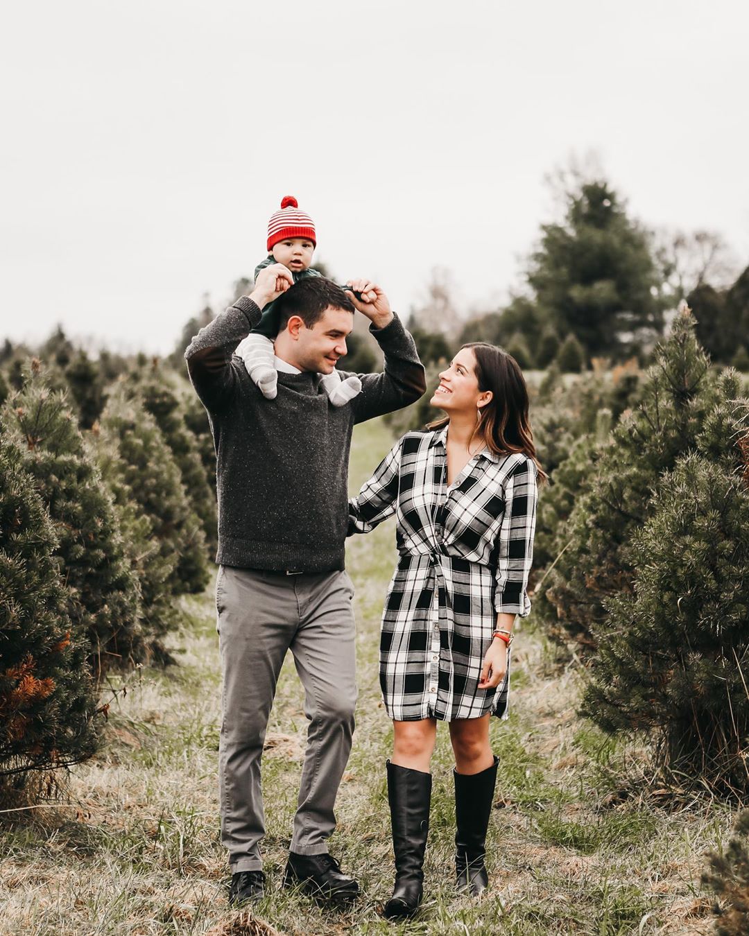 Young family strolls through holiday tree farm