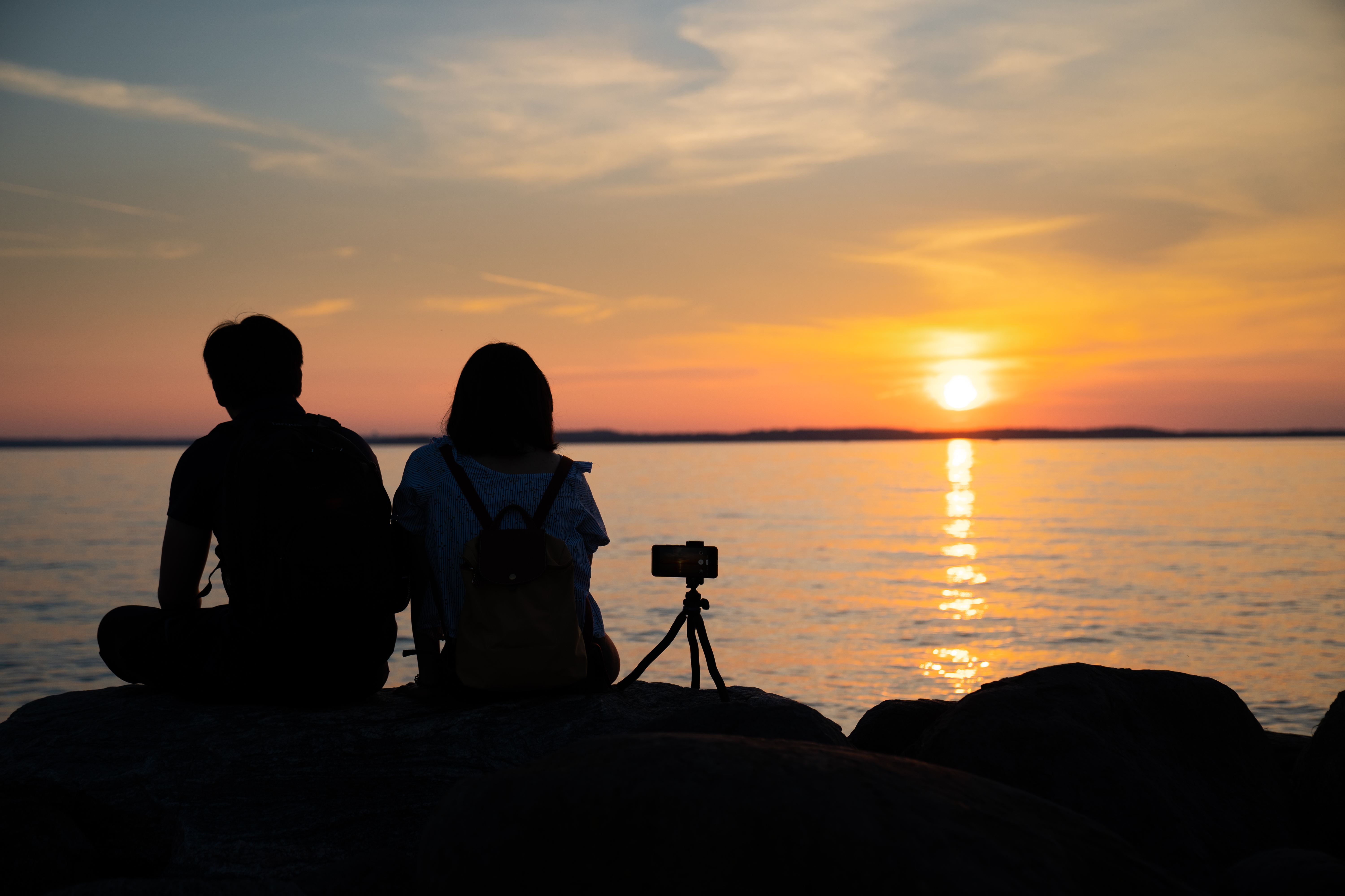 A couple watches the sun set over Lake Mendota from Tenney Park