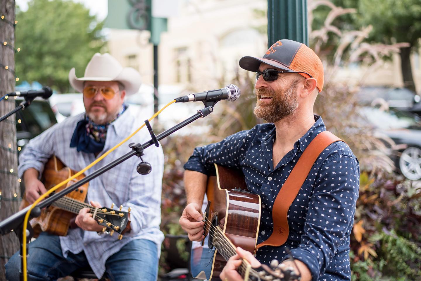 Two men singing and playing guitars