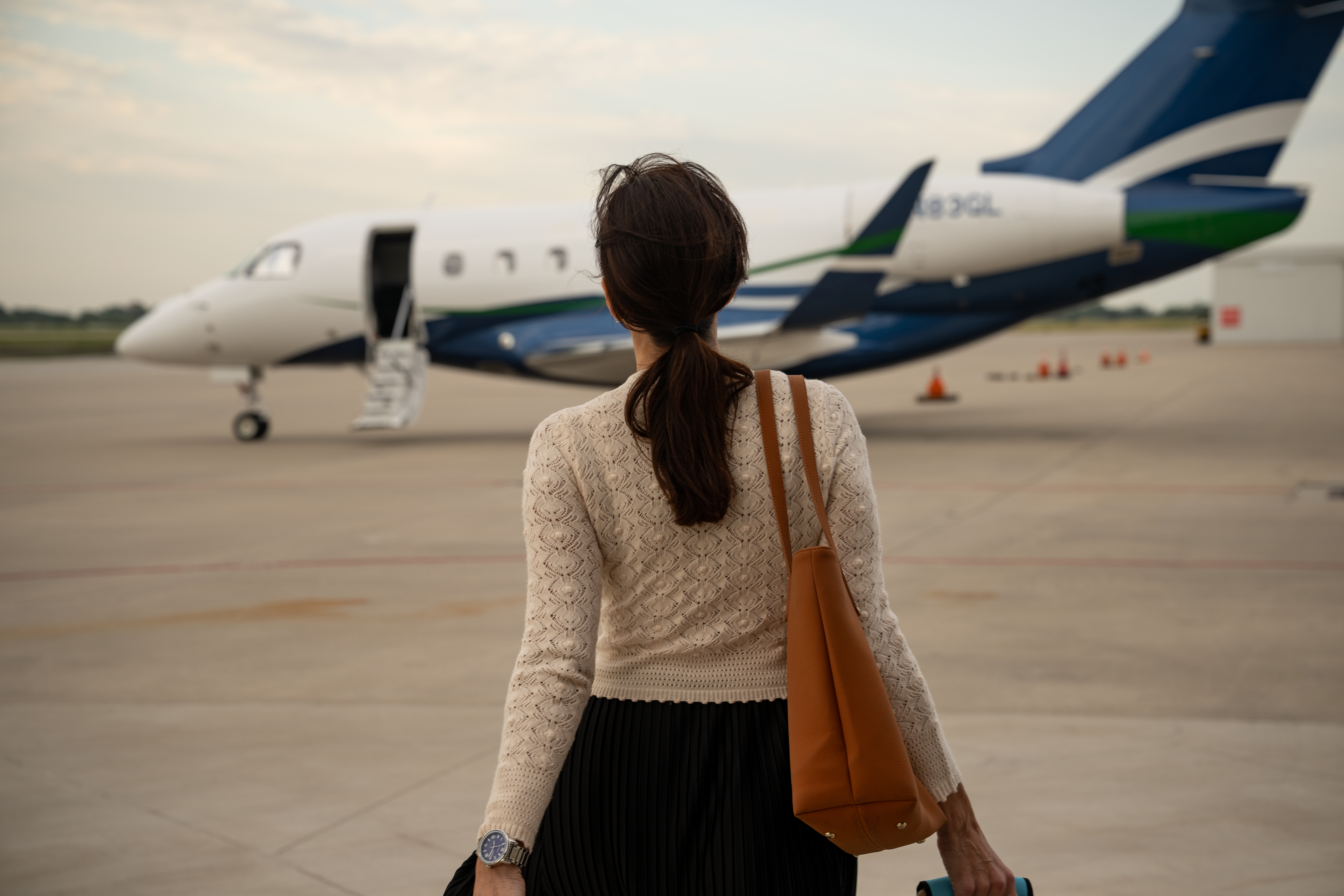 Back side of an airplane on a runway with a blue sky.