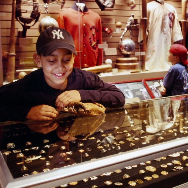Kid in Yankees hat looking at display at National Baseball Hall of Fame