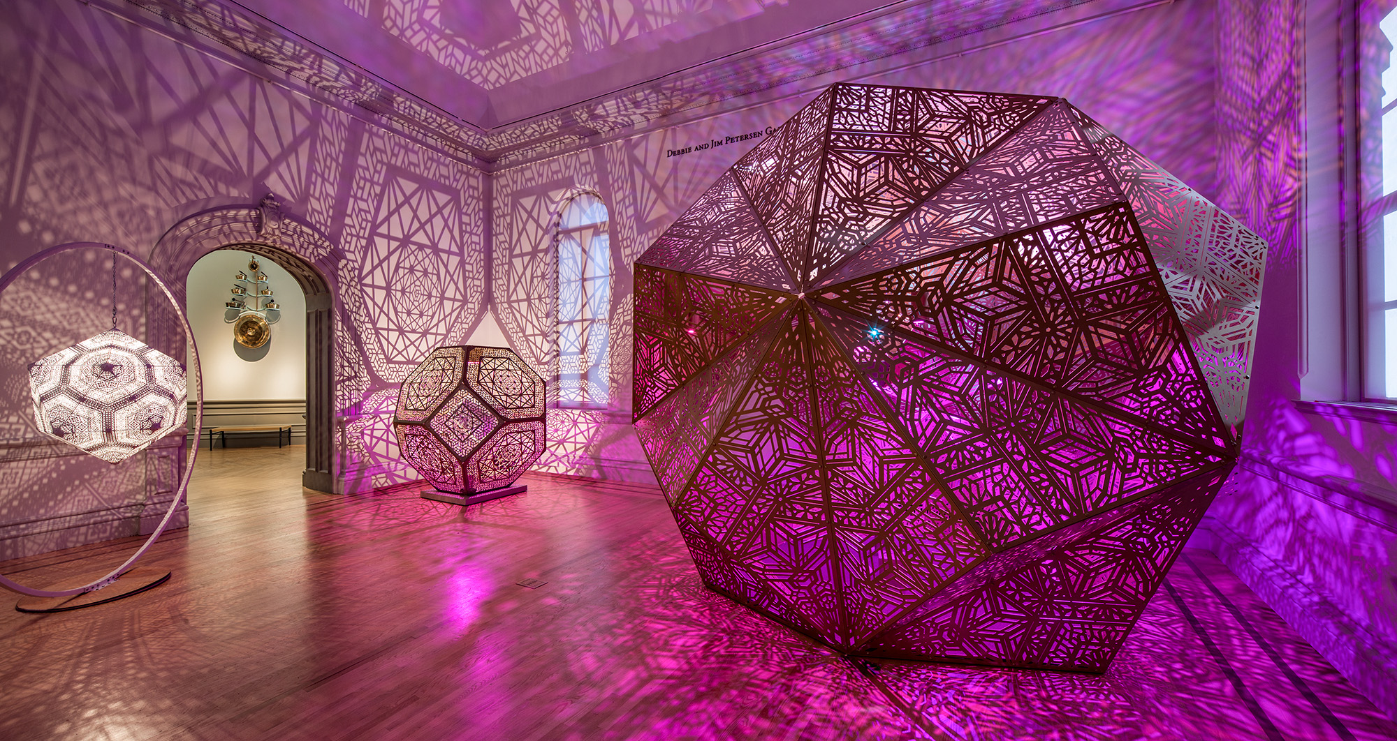 Large paper sculptures from Burning Man illuminated with pink and purple light