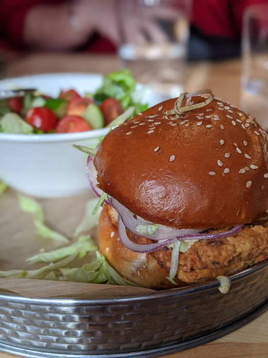 up close shot of a chicken sandwich on sesame seed bun at the kitchen by butlers pantry in covington kentucky