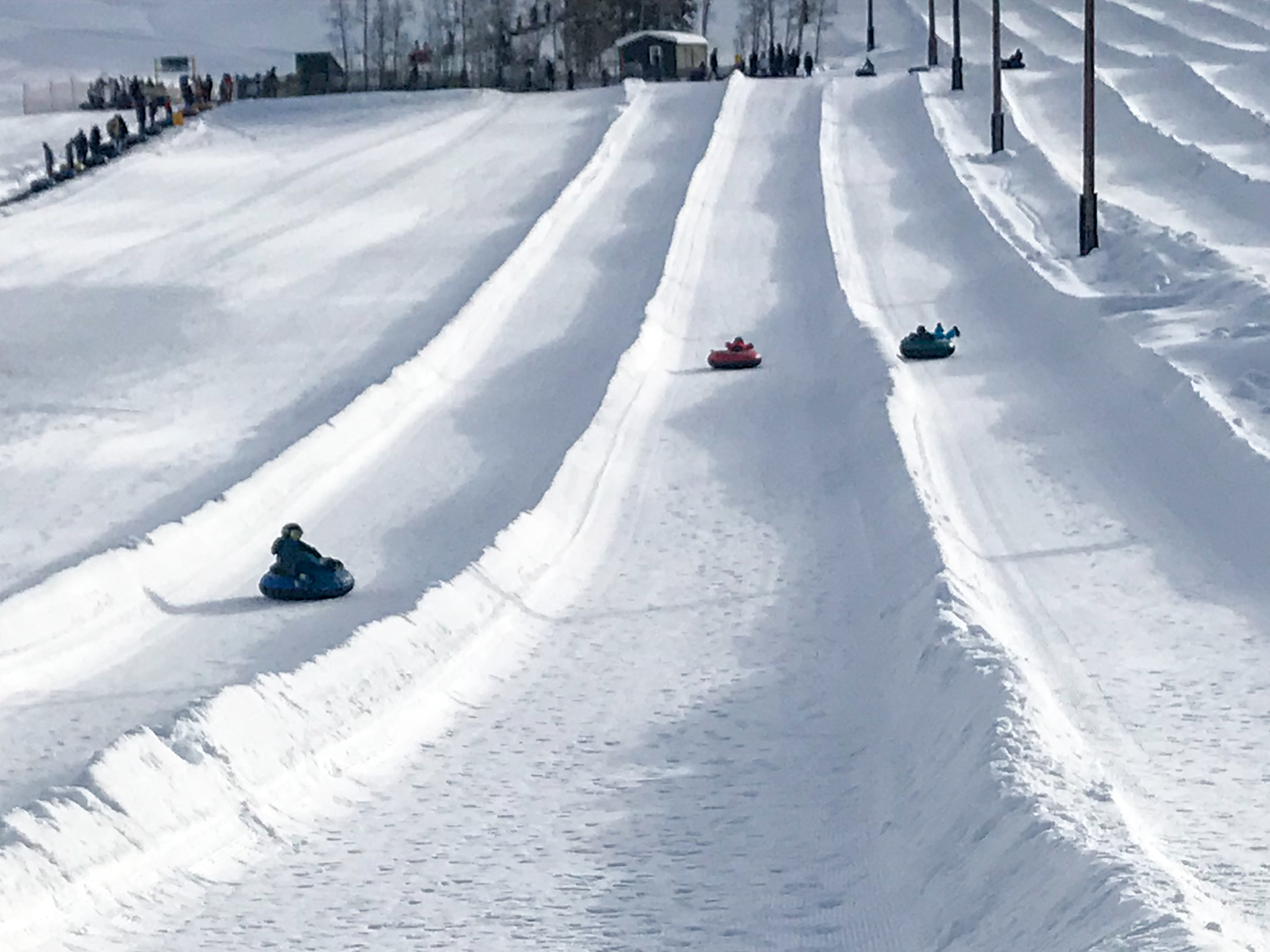three boys ride down tubes in separate lanes at Woodward Park City