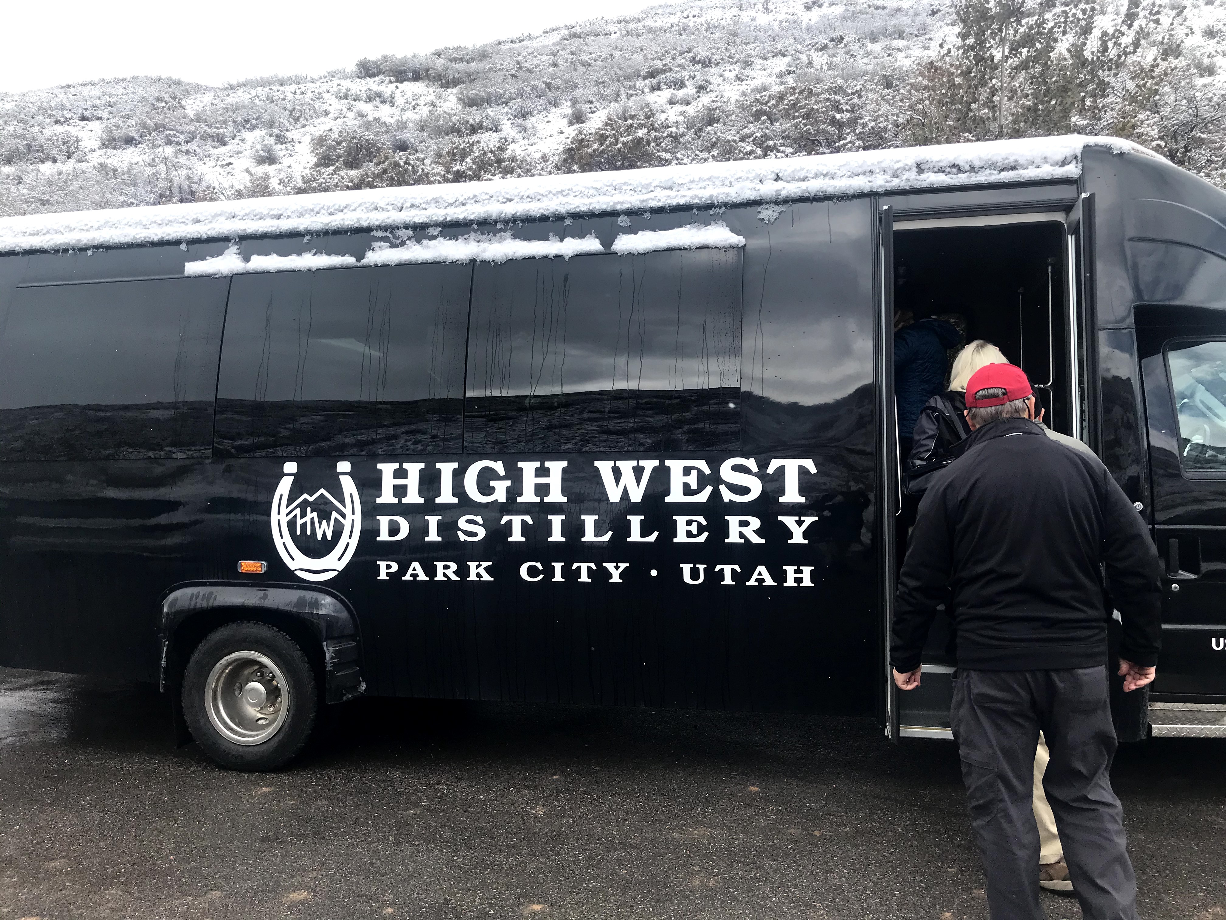 People loading into a black High West Distillery Bus