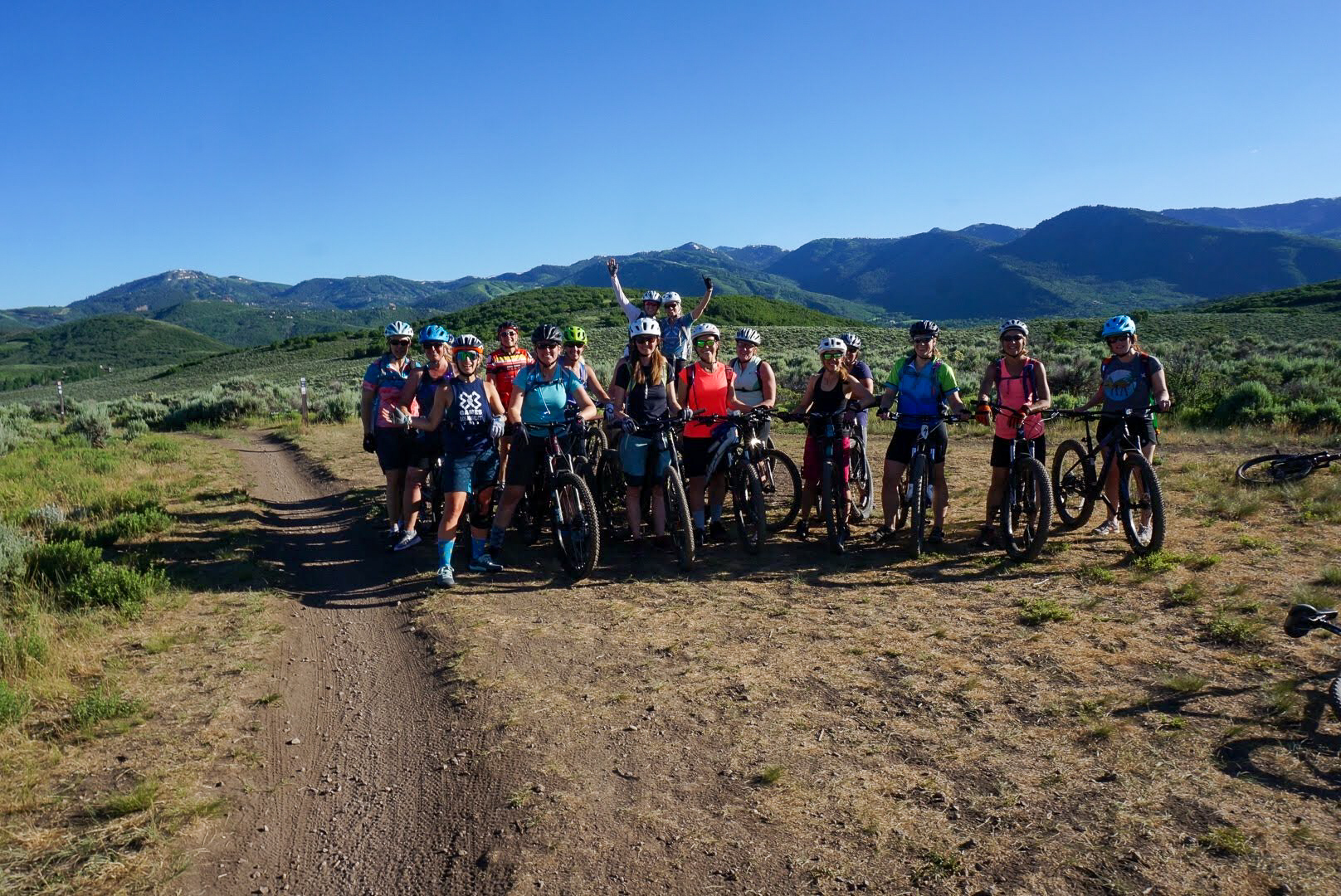 Women with mountain bikes pose for a group photo