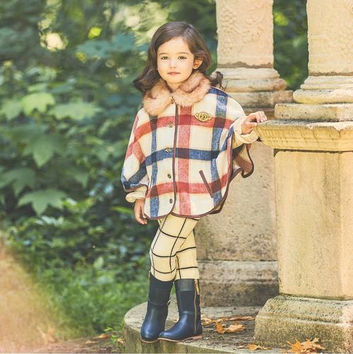 a young child posing in cute plaid fall clothes