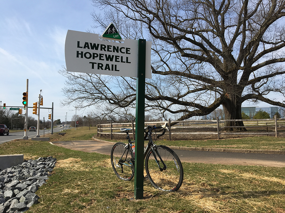 A bike parked at the sign for the Lawrence Hopewell Trail