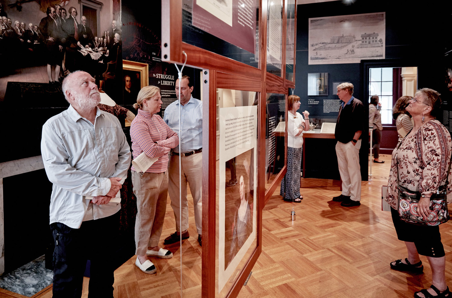 A group looking through an exhibit at morven museum