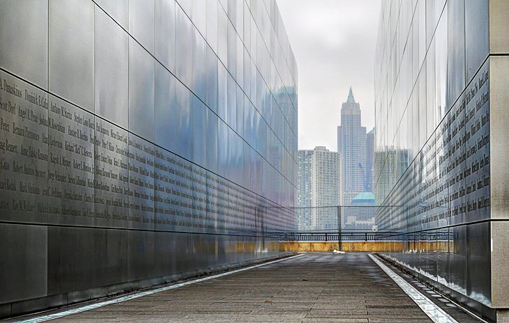 This is an image of the 9/11 memorial at Liberty State Park. The images shows two large walls forming a tunnel towards New York City. On the inside of the walls there are words of dedication to people lost at 9/11.