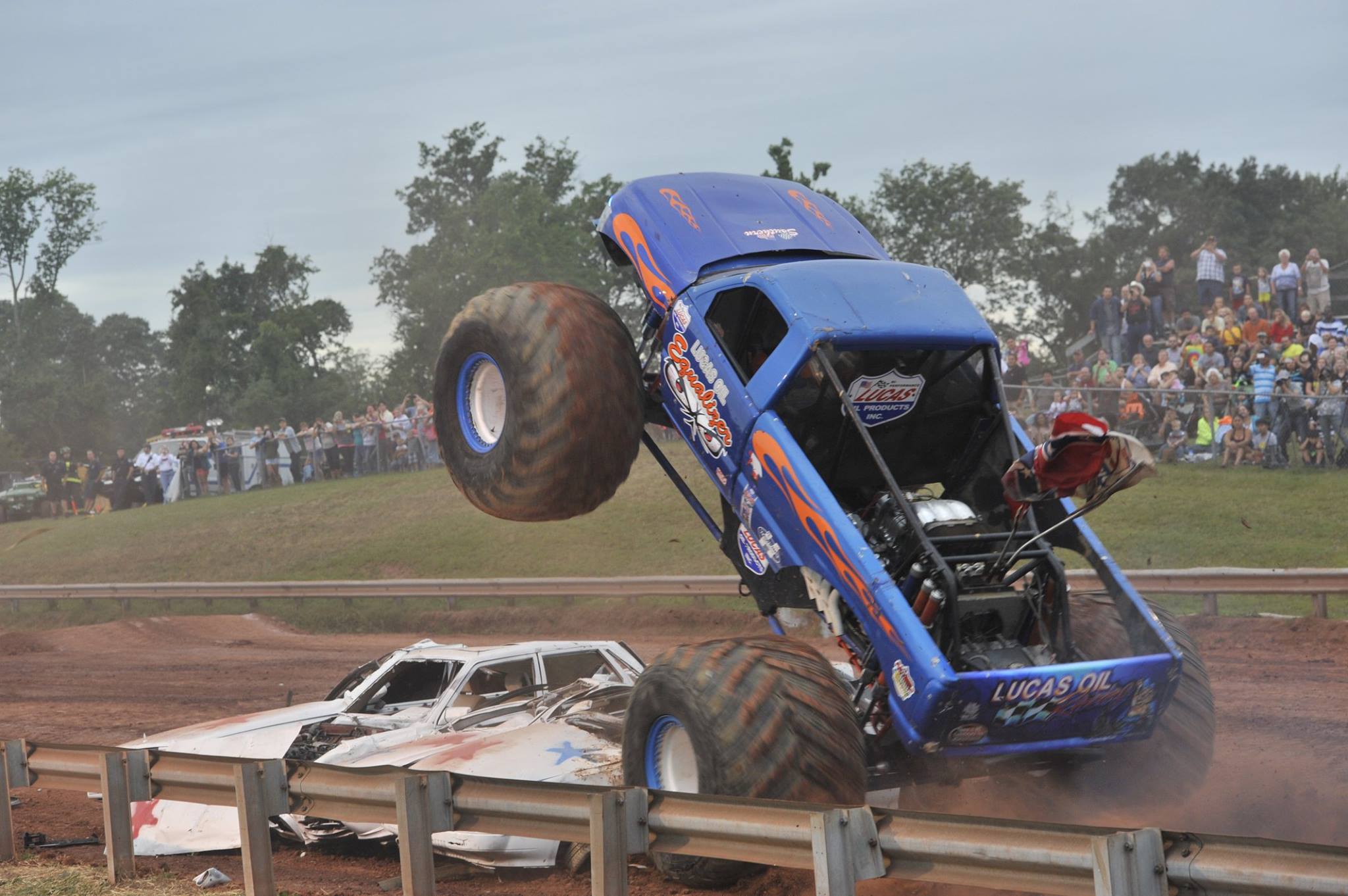 a truck driving over a car during Demolition Derby at Prince William County Fair