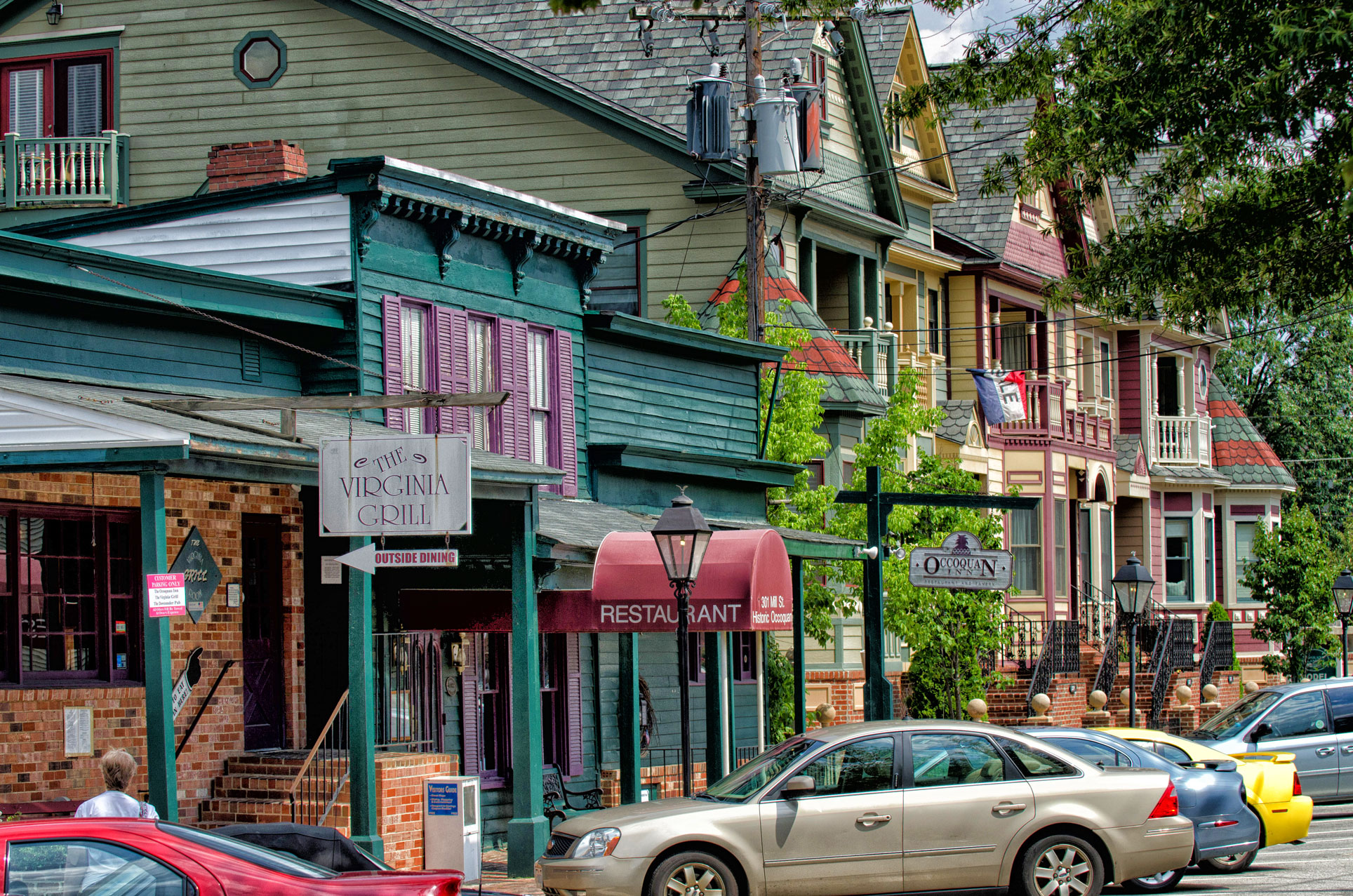 Colorful historic storefronts with cars parked outfront