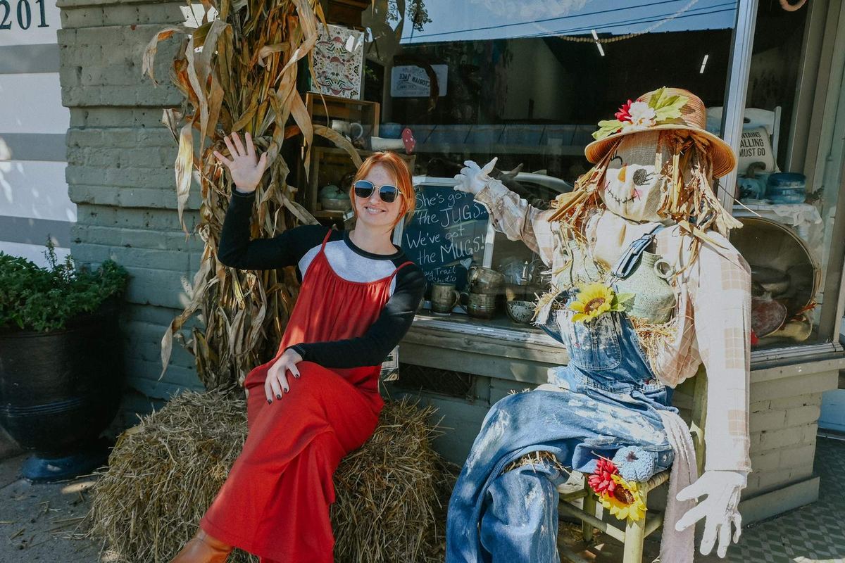 Halloween decorations and scarecrows outside a local storefront