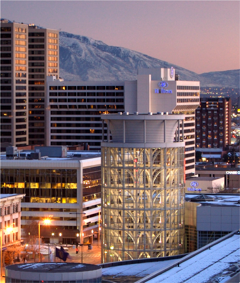 Skyline shot of the Salt Palace Salt Shaker tower with the Hilton City Center and the moutains with a sunset sky in the background