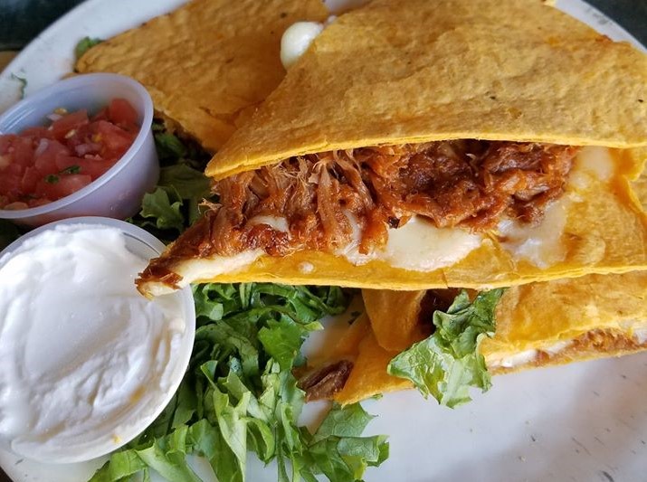 Carnitas quesadilla with sides of sour cream and salsa