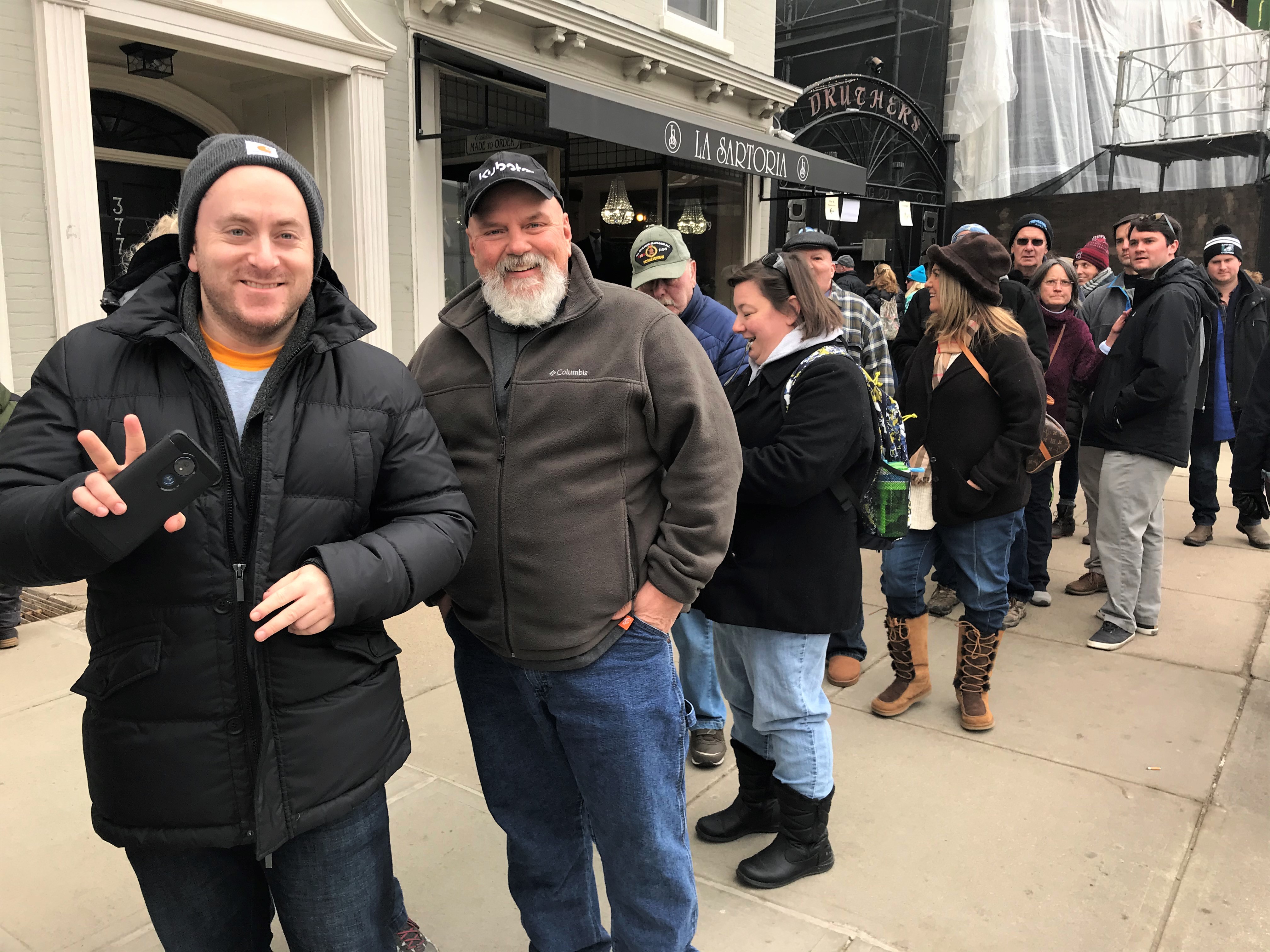 Guys standing in line outside the Adelphi