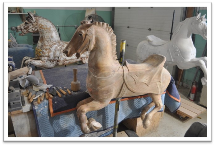 Carousel horse completely stripped of old paint standing upright