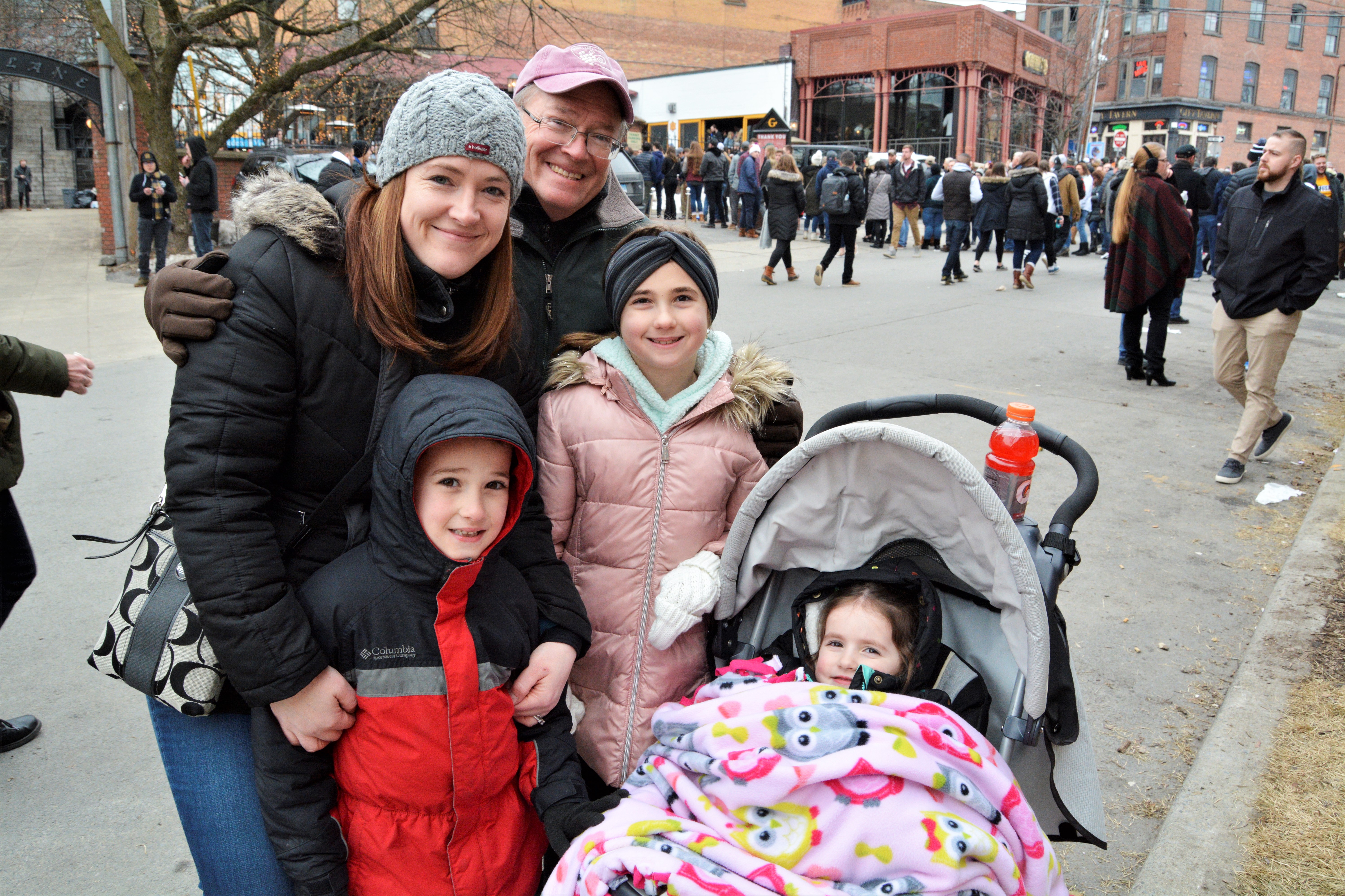 Family on the street posing with 3 small children