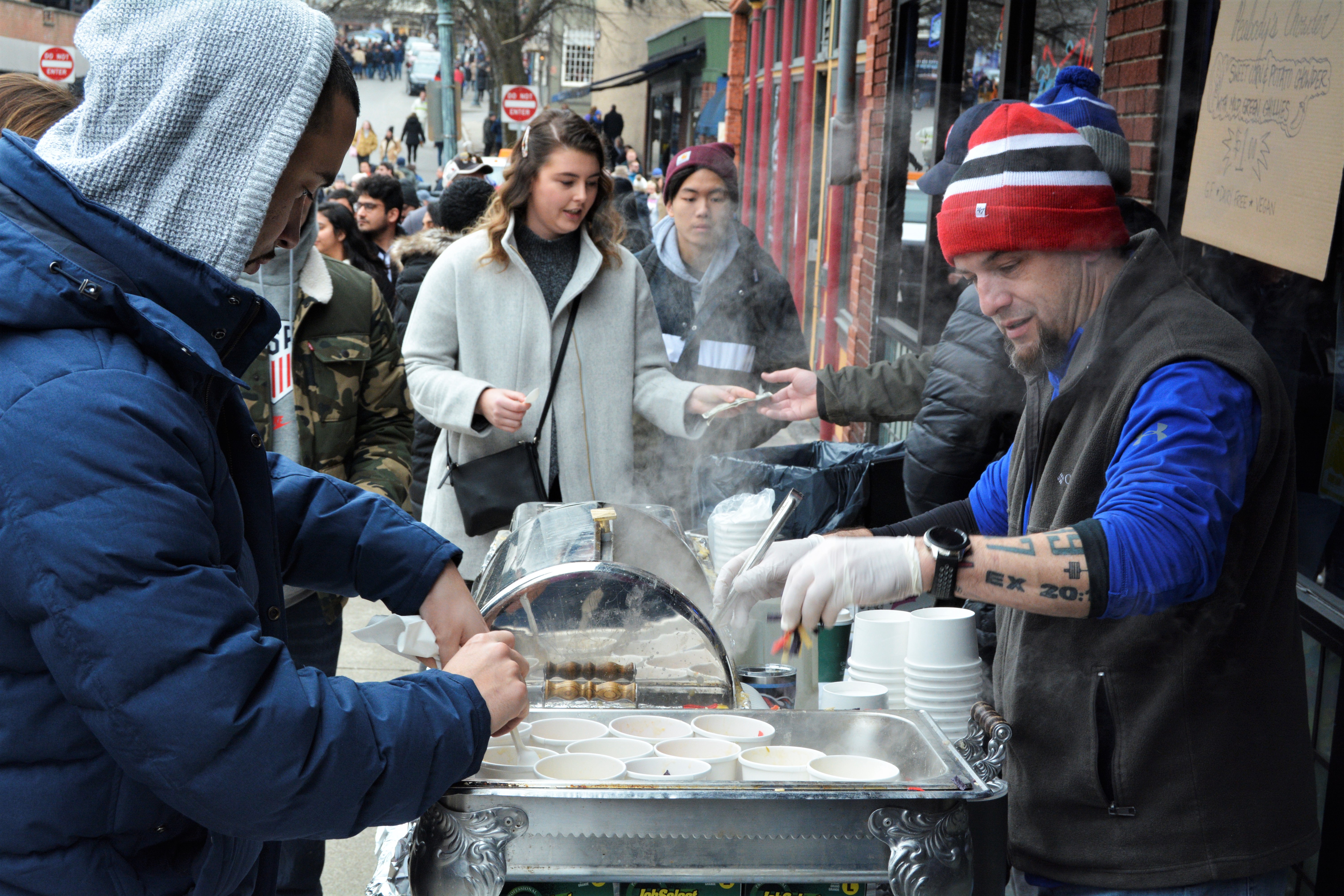 Peabody's servers behind warmers handing chowder to customer