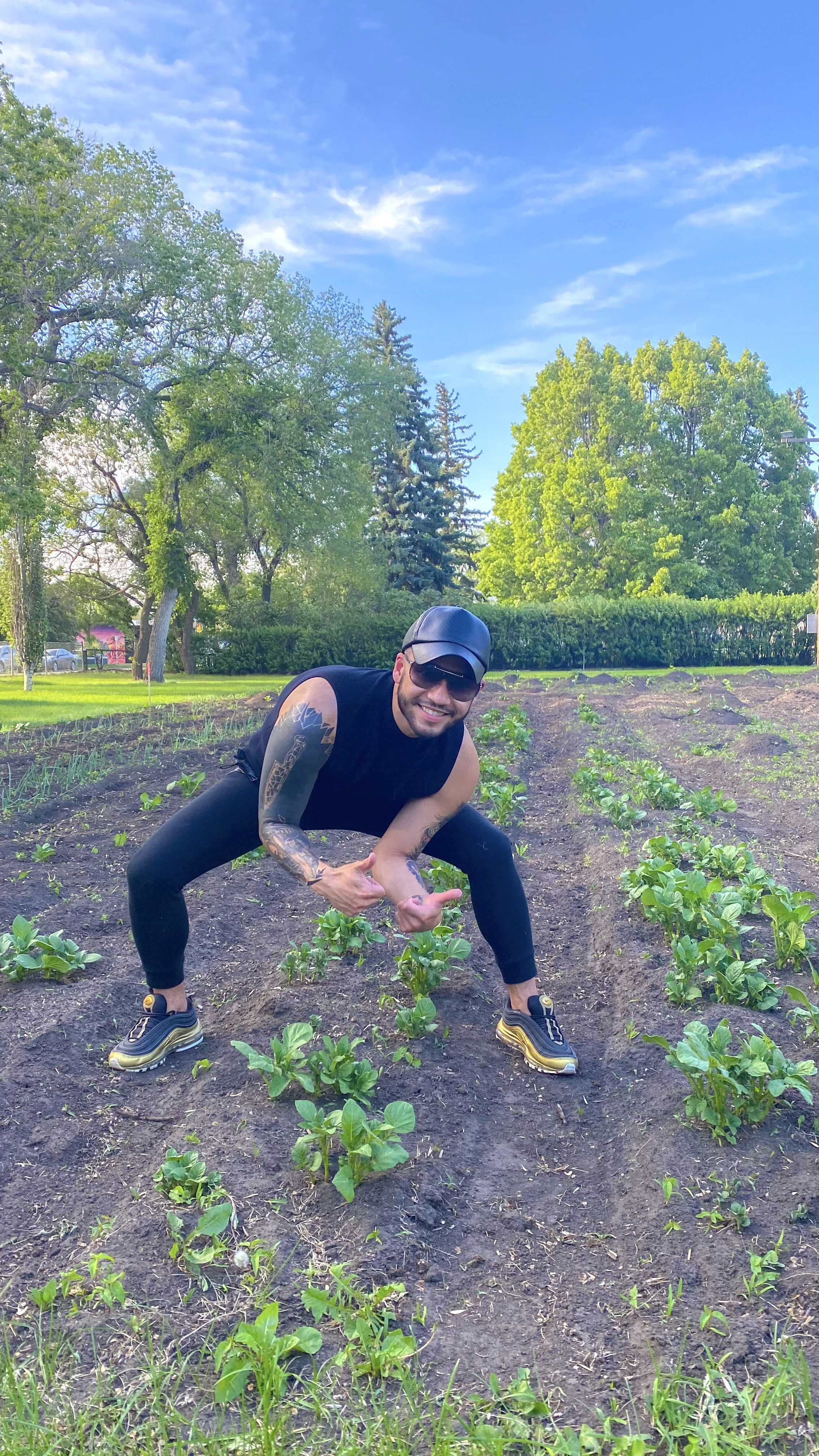 A man stands over some new plants in a garden