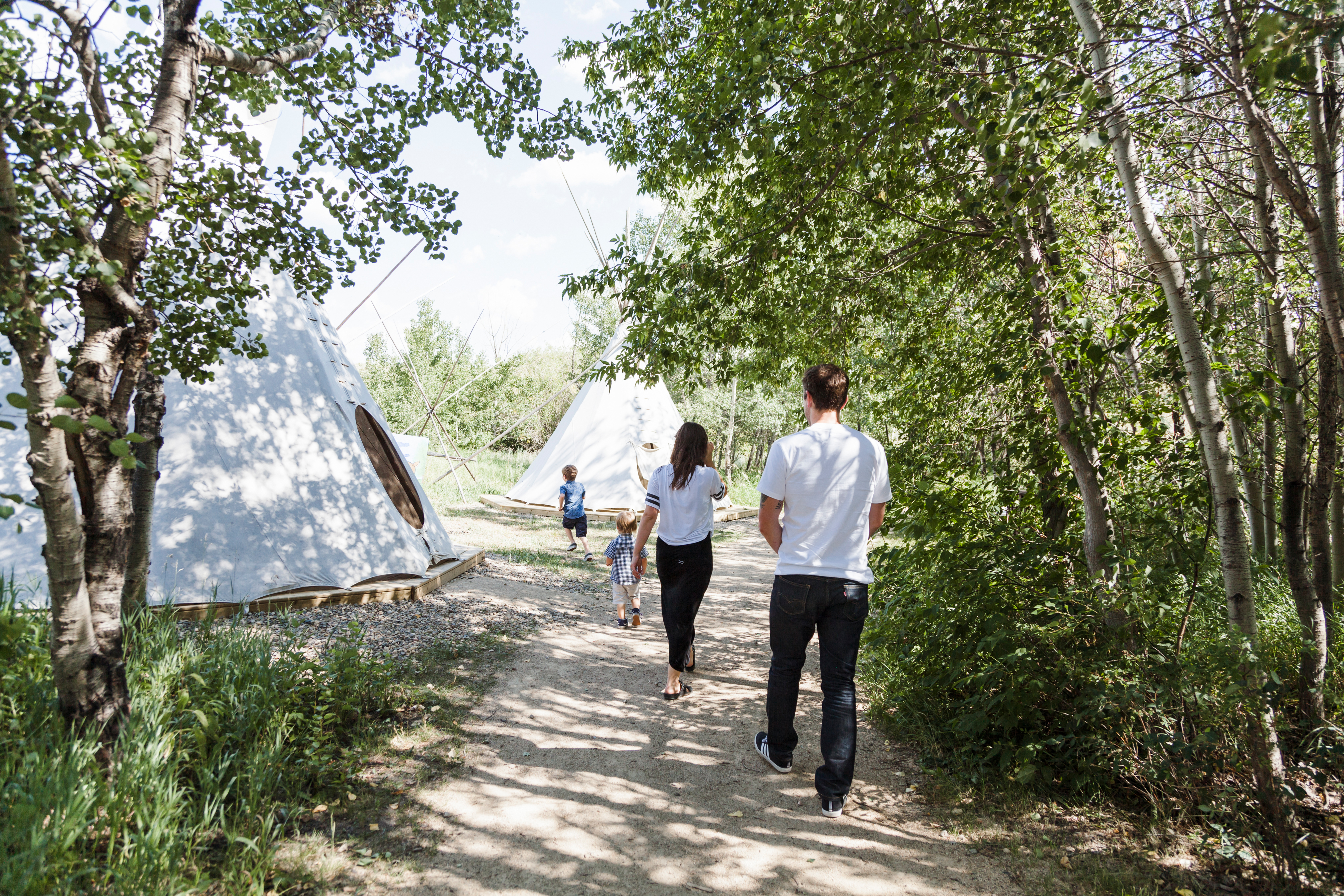 family walking towards tipis