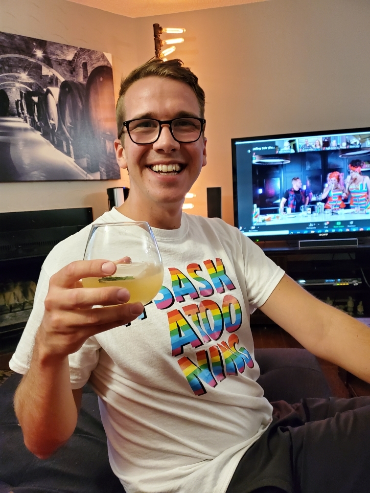 A man has a drink in front of a TV