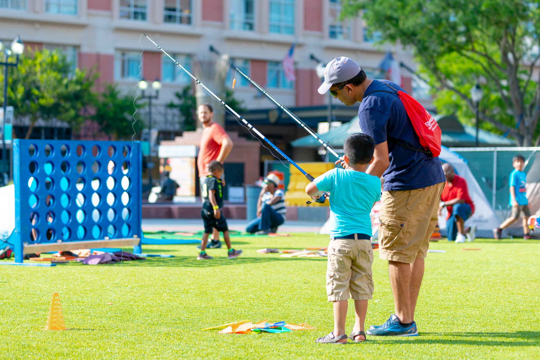 Father and son enjoying lawn fishing at Summer Family "Camp Out" in Sugar Land Town Square