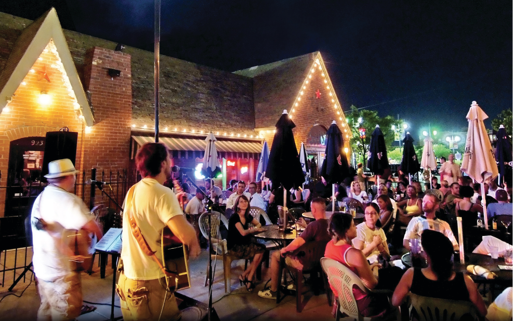 A live band performs at night in front of a patio full of people at Mort's in Wichita