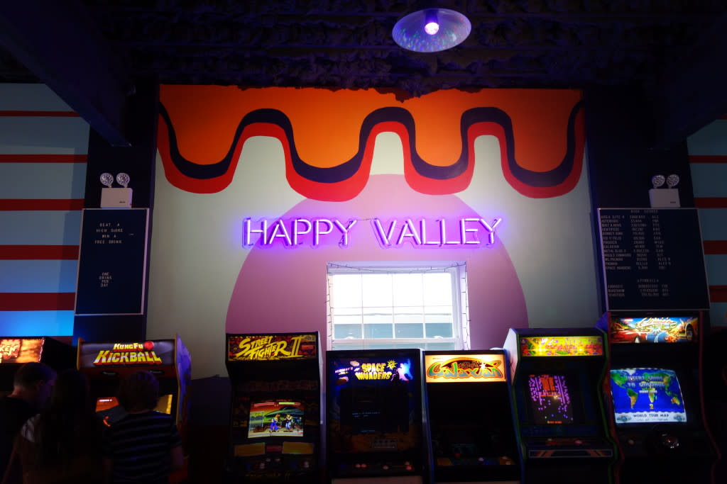 Inside Happy Valley Arcade Bar in Beacon with vintage video game consoles and neon lights