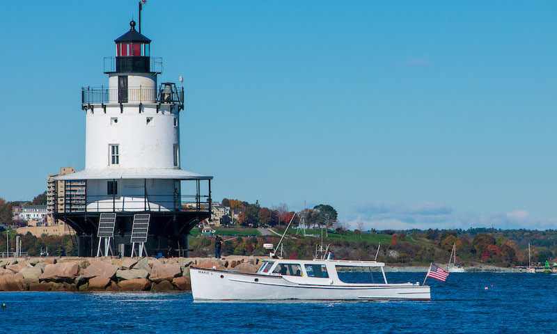 Boat by Lighthouse. Photo Credit: Casco Bay Custom Charters