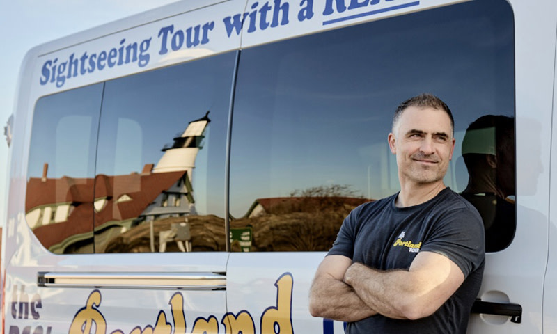 Owner in front of The Real Portland Tour Bus. Photo Credit: Michael Wilson