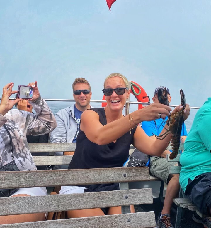 Girl with Lobster on Boat. Photo Credit: Experience Maine