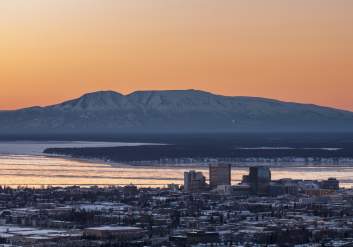 A spring sunset illuminates Sleeping Lady and downtown Anchorage.