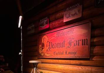 A stage with a microphone and seat for Comedy by the Creek at the Peanut Farm.