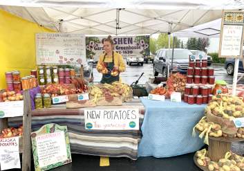 A vendor sells jams, jellies and goods at a south side Anchorage farmers market.