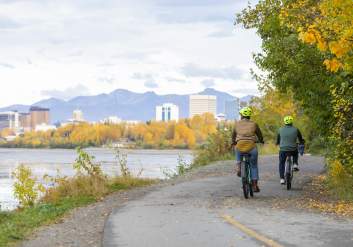 Two people riding bikes on a fall day in Anchorage along the Cook Inlet Coast.