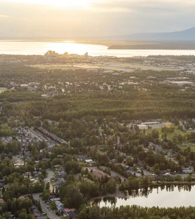 An aerial of Anchorage facing west, with Cook Inlet and Mount Susitna beyond.