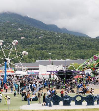 Locals and visitors browse vendor booths, and ride carnival rides at the Bear Paw Festival in Eagle River, Alaska