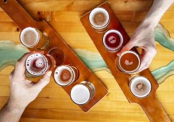 A cider flight from Double Shovel Cider Company lined up on wooden tasting paddles.