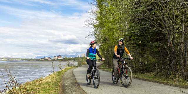 Tony Knowles Coastal trail biking trip with Anchorage, Alaska's city skyline in the background