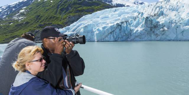 Couple photographs Portage Glacier during glacier cruise