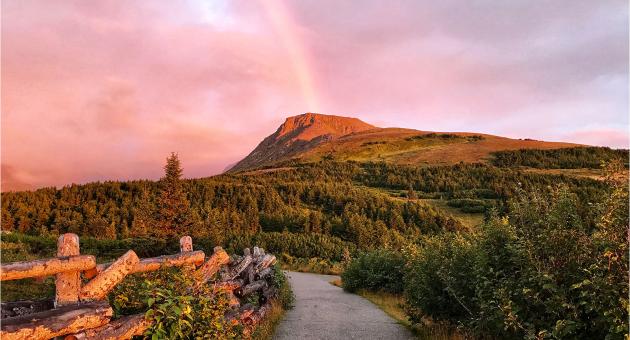 Flattop Mountain shines in the alpenglow with a rainbow in the background. Glen Alps Trailhead at Flattop one of the most accessible trails near Anchorage, Alaska.