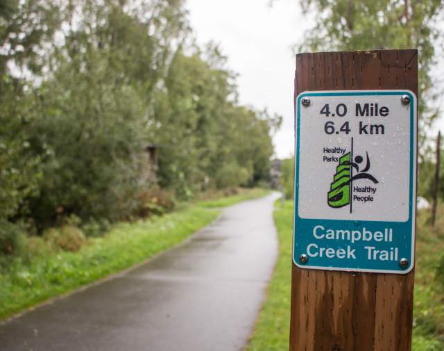 Campbell Creek trail sign with distance and trail name