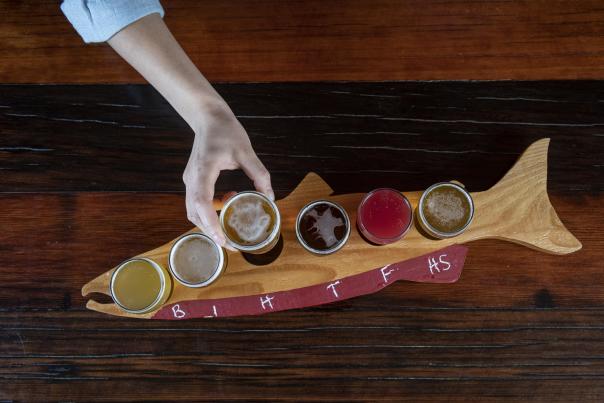 a flight of beers on a salmon-shaped board at an Anchorage brewery.