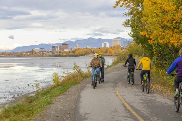 Couple biking the Tony Knowles Coastal Trail in the fall