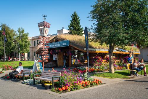 Anchorage's Log Cabin Visitor Information Center framed with flowers in the summer