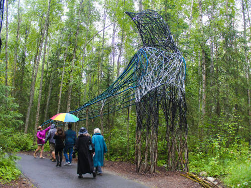 Guests walking by a piece of art at the Alaska Botanical Garden.