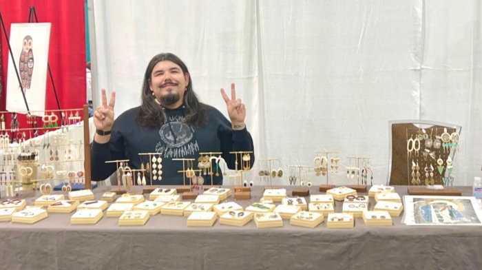 Booth at AFN with jewelry and artist's helper.