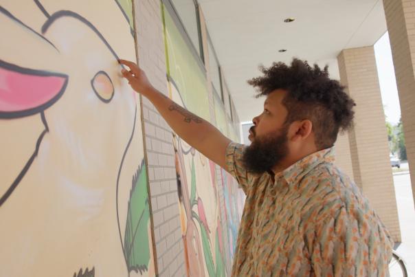 Artist Bisco works on a mural in downtown Anchorage.
