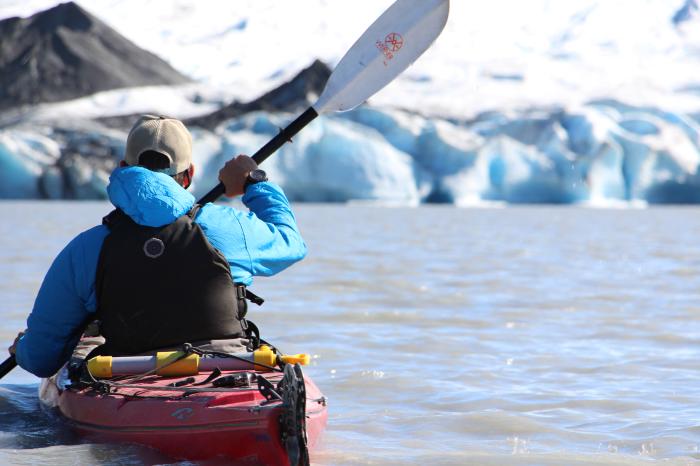 A kayaker paddles near a glacier on Spencer Lake in the Chugach Range.